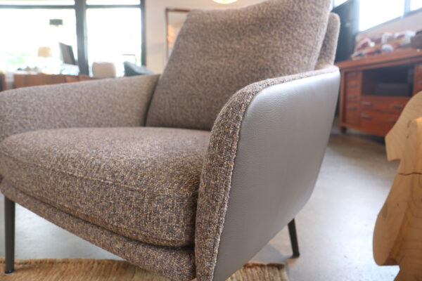 Jon - Rolf Benz. Fauteuil met brede zit gestoffeerd in grijs/bruin leder en Serra 72 van de Ploeg. Zonder levertijd verkrijgbaar bij Gulden Interieur.