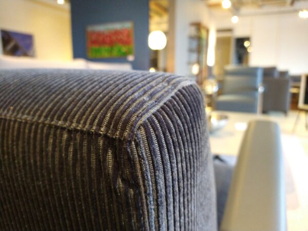 Scylla - laag - design fauteuil van Leolux met ribstof bekleding, lederen armleuning en verchroomd frame. Nu in de showroomsale bij Gulden Interieur.